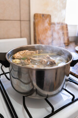 Vertical shot of metal pot filled with nutritious chicken broth