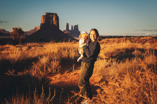 A woman with a baby is standing in Monument Valley, Arizona