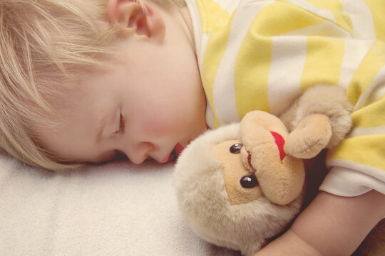 Sleeping baby boy with toy monkey