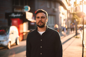 Thoughtful man walking on street in city during summer