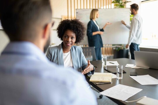 Black businesswoman speaking with colleague