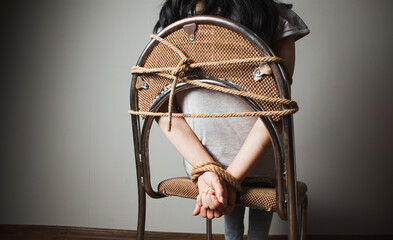 young woman tied with a rope to a chair