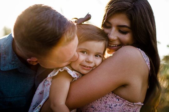 Mom & Dad Snuggling One Year Old at Sunset in San Diego