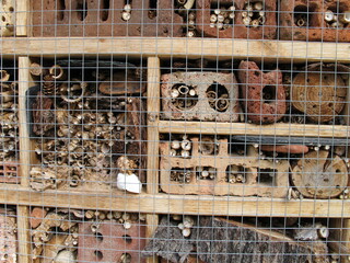 Insect hotel with brick, bamboo sticks, bark and log