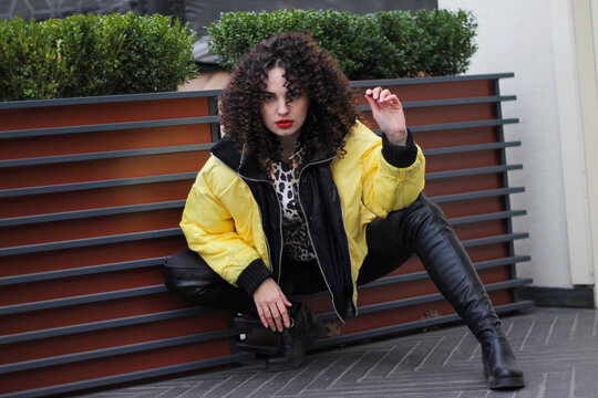 Fashionable woman posing in street of city. Model wearing white