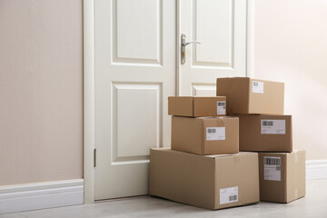 Stacked parcels near door on floor. Delivery service