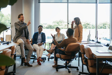 Group of Smiling Businesspeople in a Casual Meeting at their Company.

Team of five multi-ethnic employee having fun working together in an open plan office with big windows.