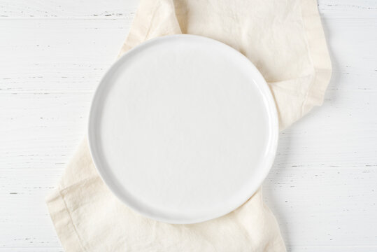 An empty plate on a white table.