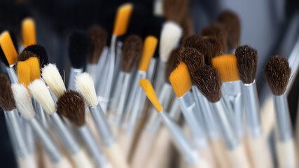 Artist's brushes for painting. Row of new brushes on gray background