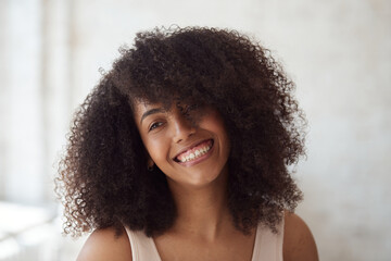 Mixed race happy female with perfect sparkling smiling. A cheerful, laughing young woman with flawless skin, natural make-up, and a dazzling face. In white boho style interior. - Powered by Adobe