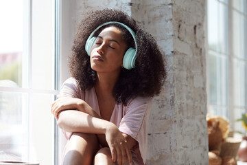 A gorgeous mixed-race woman is captivated by the pleasant sensations as she listens to relaxing...