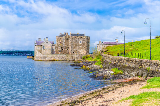 A view along the shore of Blackness Bay towards Blackness castle, Scotland on a summers day