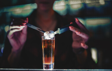 bartender hand making shot cocktail at the bar