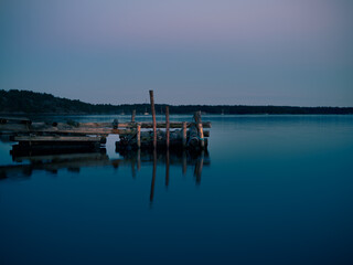 Fototapeta na wymiar A old broken jetty by the lake at night
