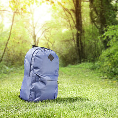 Blue school backpack on grass 