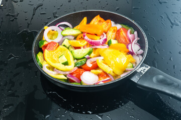 fresh vegetables cut into pieces are fried in a pan