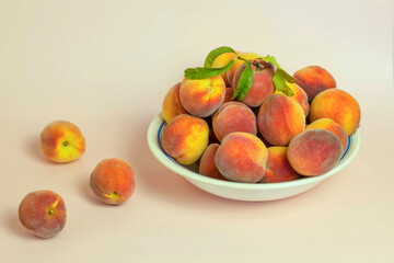 Plate with fresh peaches on pastel background