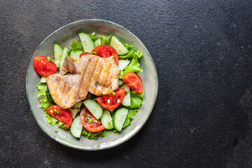 fresh salad chicken breast vegetables tomato, cucumber, lettuce diet food vitamin meal snack on the table copy space food background rustic. top view keto or paleo diet veggie 