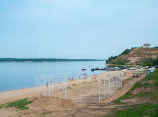 Mariinsky Posad, Russia - August, 09 2021: View on the Volga river coast and beach with volleyball court in cloudy day.