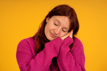 Young tired woman posing with eyes closed and hands on face.