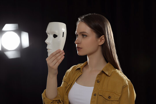 Professional actress rehearsing with mask on stage in theatre