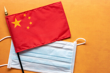 Chinese flag with paper mask for covid origin concept