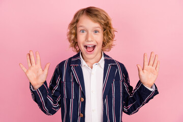Photo of young excited little boy happy positive smile wave hello glad isolated over pink color background © deagreez