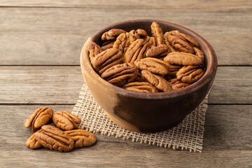 Pecan nuts in a bowl over wooden table