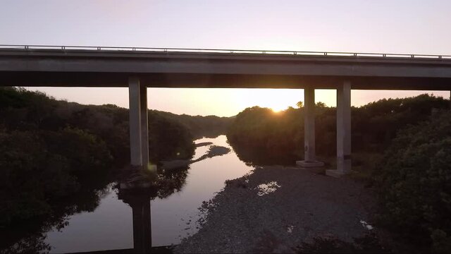 AERIAL - camera goes under bridge filming waterway