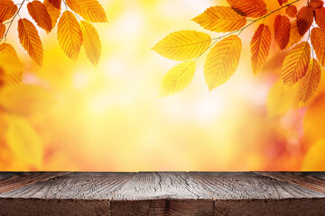 Empty wooden table and orange autumn leaves over blurred nature background. Fall background with...