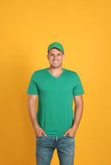 Happy man in green cap and tshirt on yellow background. Mockup for design