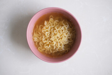 Noodle soup in a bowl. Top view isolated on white