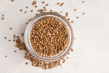 Coriander seed in a bowl on a white background. View from above