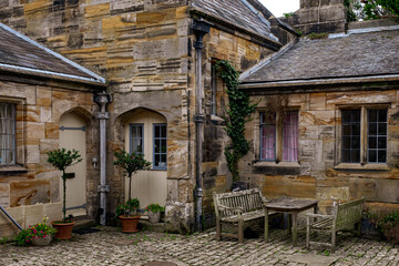 sandstone buildings satding on cobbled courtyard