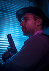 Suspicious private detective near the window with blinds, cinematic noir scene