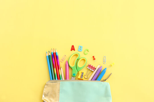 Back to school concept. Top view image of student stationery over pastel yellow background