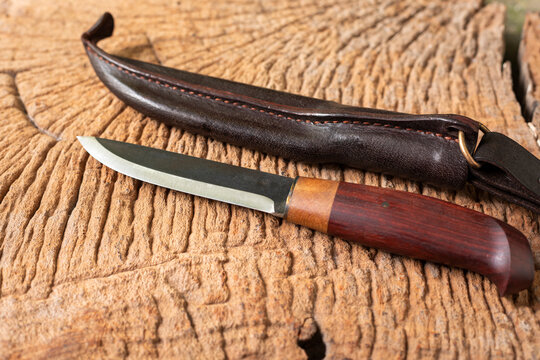 finnish puukko knife placed on old wooden table