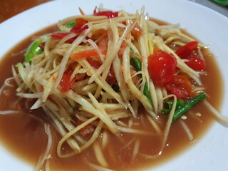 SOM TUM THAI (Thai papaya salad) Spicy food, cut into long pieces, papaya, tomatoes, yard long beans, seasoned with lime juice, chili, fish sauce and sugar (may add peanuts or dried shrimp) 
