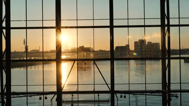 Sunrise and city skyline reflecting in water shot in a glass elevator