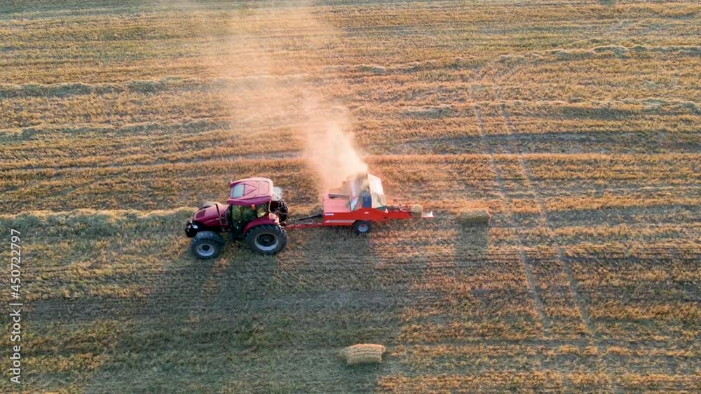 Poster An aerial view of a red tractor plowing a vast agricultural field