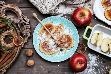 Apple fritters with powdered sugar, honey and muesli.