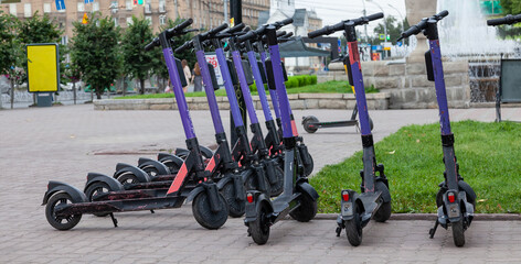 Electric scooters in row on the parking lot City bike rental system, public kick scooters on the street electric scooter in Novosibirsk, Russia