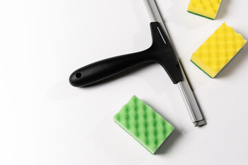 cleaning tools, scraper, window nozzle and colored washcloths on a white background