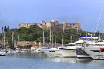 Fototapeta na wymiar Le port d'Antibes avec ses nombreux bateau protégé par le fort carré en arrière plan qui domine l'entrée du port 