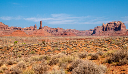 Fototapeta na wymiar Wispy clouds rise above the pinnacles and red rock monuments at the Valley of the Gods in Utah