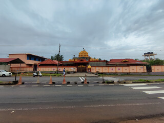 View of the beautiful ancient architecture temple on the side of the road under the rain cloudy sky