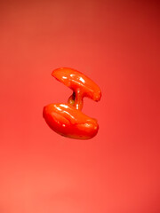 tomato with sauce on red background