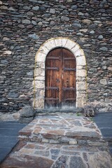 Old door of a small town in the Pyrenees of Andorra. Mountain architecture. Rock, stone and wood