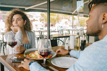 Woman getting bored at a date at a restaurant.