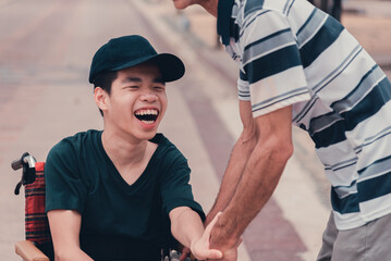 Asian disabled teenager boy on wheelchair and carer in public places, Lifestyle of happy disability...